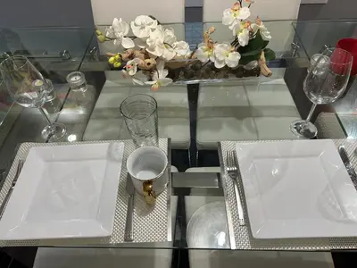 a table with two white plates and a vase with flowers at Jahsavvy's Nest in Hamilton