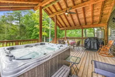 a jacuzzi tub on a wooden deck at Blue Water Dunes Cottage in Tiny