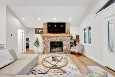 a living room with a couch and a fireplace at Blue Water Dunes Cottage in Tiny