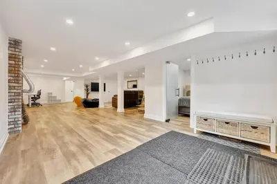 a large white living room with a fireplace at Blue Water Dunes Cottage in Tiny