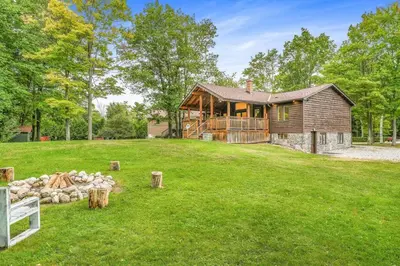 a home with a large yard with a house at Blue Water Dunes Cottage in Tiny