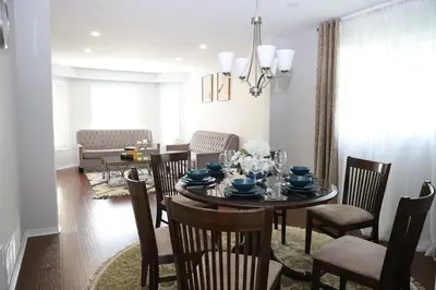 a dining room and living room with a table and chairs at Lavish 4BR House Near Simcoe Lake & FH Resort in Innisfil