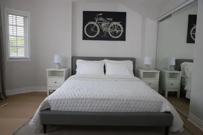 a bedroom with a bed and a bike on the wall at Lavish 4BR House Near Simcoe Lake & FH Resort in Innisfil