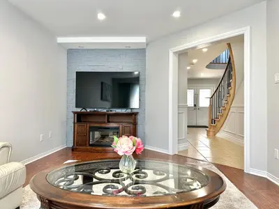 a living room with a coffee table and a fireplace at Lavish 4BR House Near Simcoe Lake & FH Resort in Innisfil