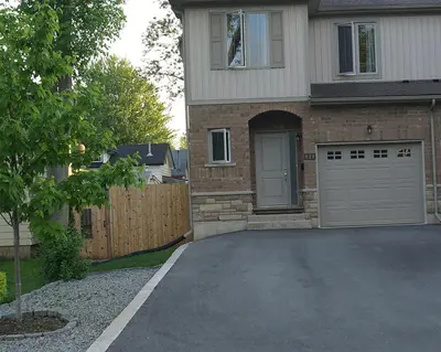 a house with a driveway with a garage at Pelican guest house. Village style living. Spend vacation time in Eco place! in Fort Erie