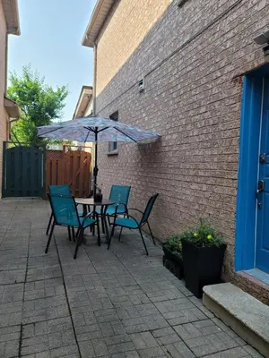 a patio with a table and chairs and an umbrella at RoryHouse in Toronto