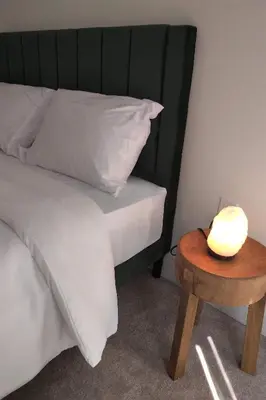 a bed with a white pillow and a wooden table at GGP Boutique Townhome in Vaughan