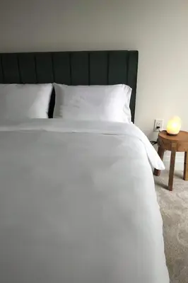 a large white bed with a green headboard and a table at GGP Boutique Townhome in Vaughan