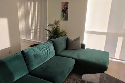 a green couch in a living room with a plant at GGP Boutique Townhome in Vaughan