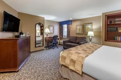 a hotel room with a large bed and a desk at The Parlour Inn, an Ascend Collection Hotel in Stratford