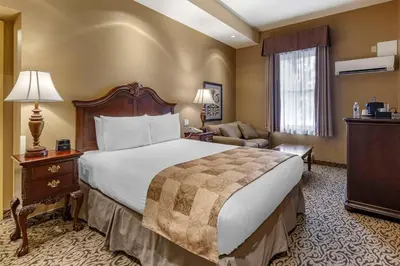a hotel room with a large bed and a couch at The Parlour Inn, an Ascend Collection Hotel in Stratford
