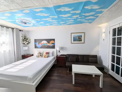 a bedroom with a bed and a couch and a blue ceiling at Cozy and Quiet Homestay with Private Bathroom in Toronto