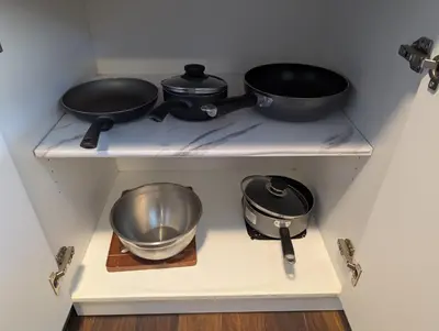 two pots and pans on a shelf in a kitchen at Cozy and Quiet Homestay with Private Bathroom in Toronto