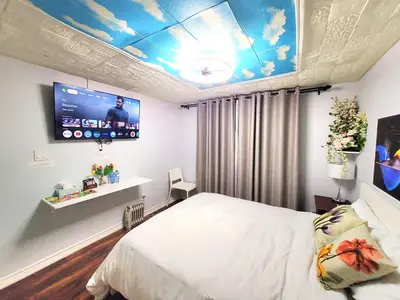 a bedroom with a bed and a flat screen tv at Cozy and Quiet Homestay with Private Bathroom in Toronto