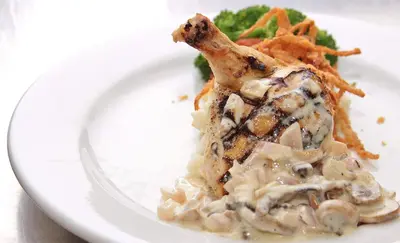 a white plate with a piece of chicken with mushroom gravy at Trillium Resort & Spa in Port Sydney