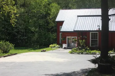 a red barn with a table and chairs in front of it at Trillium Resort & Spa in Port Sydney