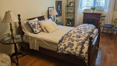 a bedroom with a bed with a blue and white comforter at Greater Toronto B&B in Oakville