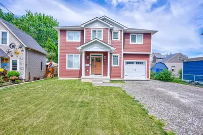 a red house with a driveway in a yard at Lake view cottage with three ensuites and elevator in Fort Erie