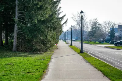a sidewalk with street lights next to a road at Lake view cottage with three ensuites and elevator in Fort Erie