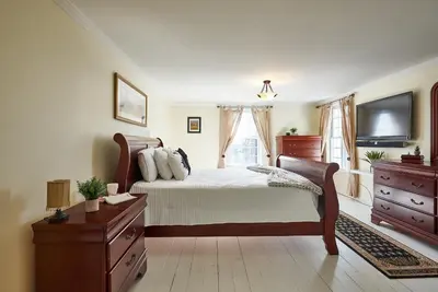 a bedroom with a bed and a flat screen tv at Bramasole Bed and Breakfast in Roseneath