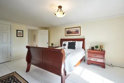 a bedroom with a bed and a dresser and a lamp at Bramasole Bed and Breakfast in Roseneath