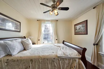 a bedroom with a bed with a ceiling fan at Bramasole Bed and Breakfast in Roseneath