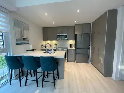 a kitchen with a island with bar stools in it at 2 bedroom 2 bath Aquarius, Friday Harbour, Innisfil, Barrie in Innisfil