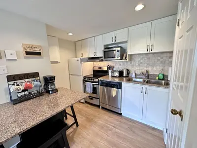a kitchen with white cabinets and stainless steel appliances at Blue Mountain at your Door Step in Blue Mountains