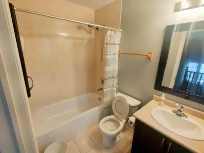 a bathroom with a toilet and a tub and a sink at Affordable Room with FREE Parking in Newmarket ON in Newmarket