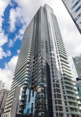 a tall building with glass windows in a city at Luxury King Bed Condo with Stunning City Views in Toronto