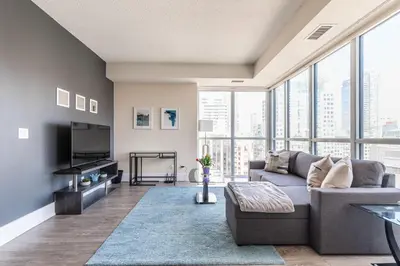 a living room with a couch and a tv at Luxury King Bed Condo with Stunning City Views in Toronto