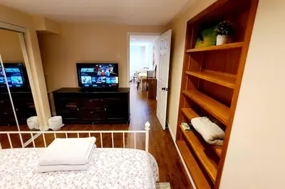 a bedroom with a bed and a television in a room at Spacious and bright unit with natural light. in Pickering