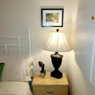 a lamp on a night stand next to a bed at Spacious and bright unit with natural light. in Pickering