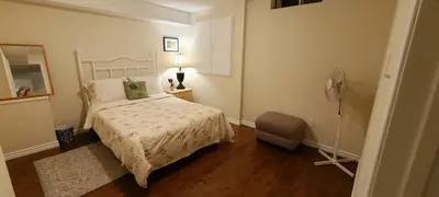 a bedroom with a bed and a fan at Spacious and bright unit with natural light. in Pickering
