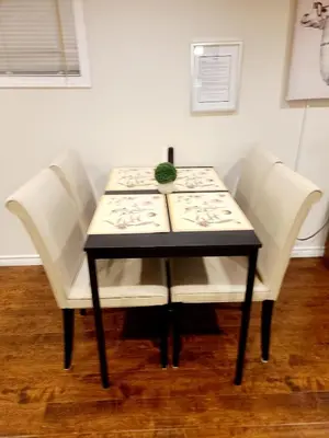 a table with white chairs and a plant on it at Spacious and bright unit with natural light. in Pickering