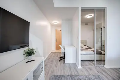 a bedroom with a bed and a desk and a mirror at Cityscape 1BR Condo with Private Balcony amd WFH setup in Toronto