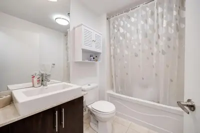 a bathroom with a toilet and a sink and a shower at Cityscape 1BR Condo with Private Balcony amd WFH setup in Toronto