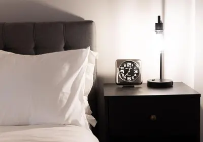 a clock sitting on a nightstand next to a bed at One of Toronto s finest 1BR Condo with a WFH Setup in Toronto