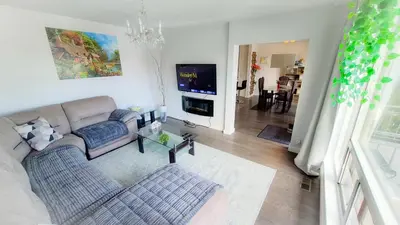 a living room with a couch and a tv at Richview Gardens Suite, 3-bdr in Toronto