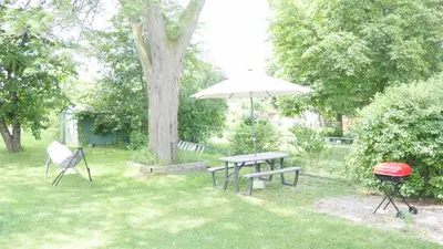a picnic table with an umbrella and a grill at Richview Gardens Suite, 3-bdr in Toronto