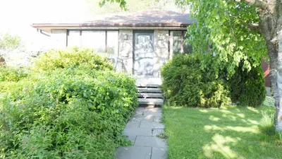 a small stone house with a pathway leading to it at Richview Gardens Suite, 3-bdr in Toronto