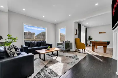 a living room with a couch and a table at Oshawa Family Haven - Luxury 7BR Villa with Cozy Fireplaces & Hot Tub in Oshawa