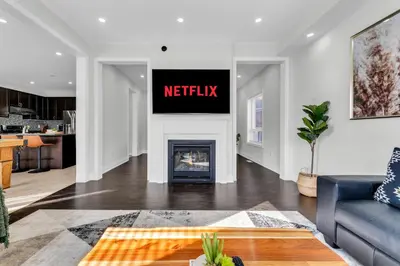 a living room with a fireplace with ametix sign on the wall at Oshawa Family Haven - Luxury 7BR Villa with Cozy Fireplaces & Hot Tub in Oshawa