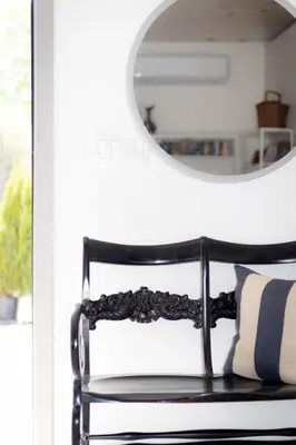 a black chair in front of a mirror at The Barns of Brighton Near Prince Edward County in Brighton