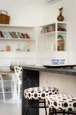 a kitchen with a counter with two chairs and a table at The Barns of Brighton Near Prince Edward County in Brighton