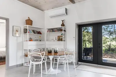 a dining room with white chairs and a table at The Barns of Brighton Near Prince Edward County in Brighton
