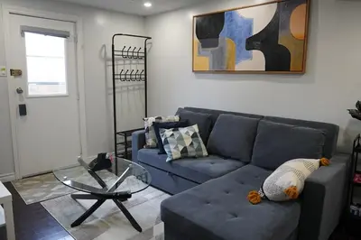 a living room with a blue couch and a glass table at Patio privé, hébergement équipé et spacieux. in Hamilton