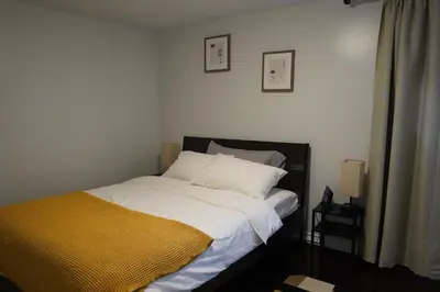 a bedroom with a bed with a yellow blanket on it at Patio privé, hébergement équipé et spacieux. in Hamilton