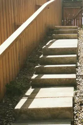 a set of concrete steps next to a fence at Patio privé, hébergement équipé et spacieux. in Hamilton
