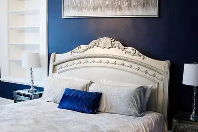 a bedroom with a white bed with a blue wall at Lakehurst Estate in Cobourg